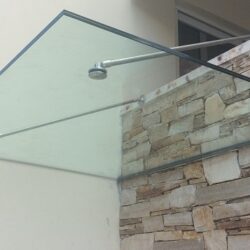 Κρεμαστό γυάλινο στέγαστρο σε είσοδο κατοικίας