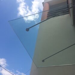 Κρεμαστό γυάλινο στέγαστρο σε είσοδο κατοικίας